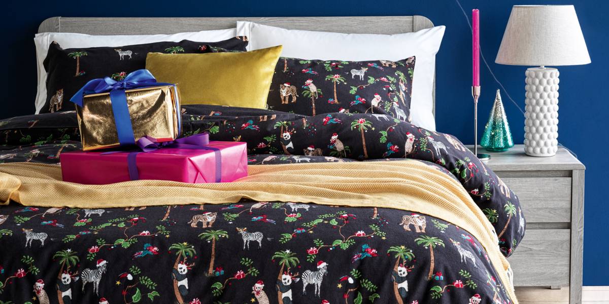 A bed made with wrapped Christmas presents on top. Homeware